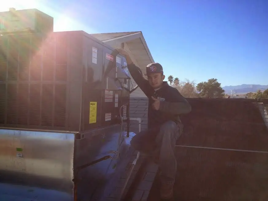 HVAC technician performing AC Tune-Up on a rooftop unit in Meadow Lakes